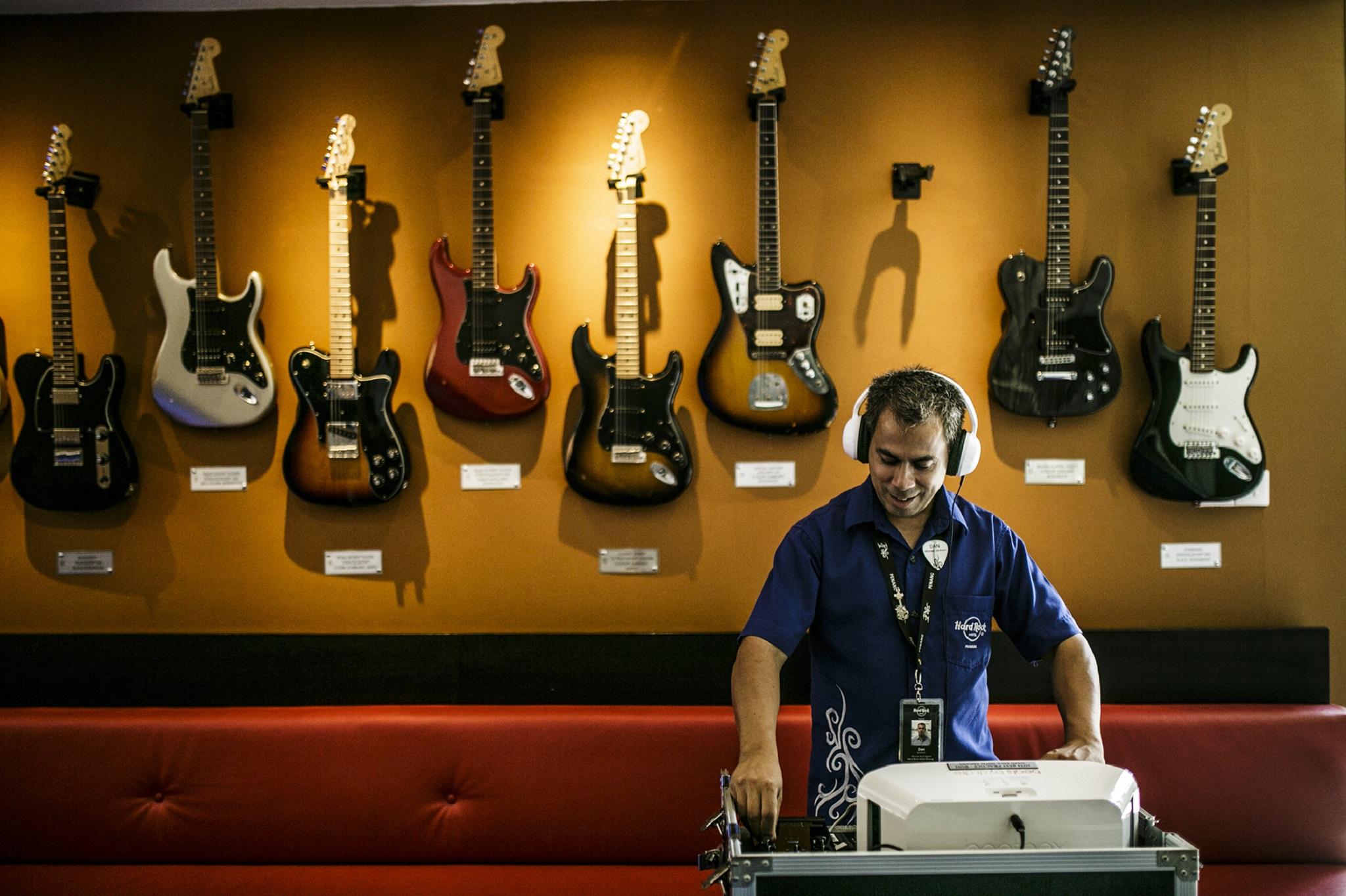 Hard Rock Hotel Penang Batu Ferringhi Eksteriør billede A guitar store employee listens to a customer's selection